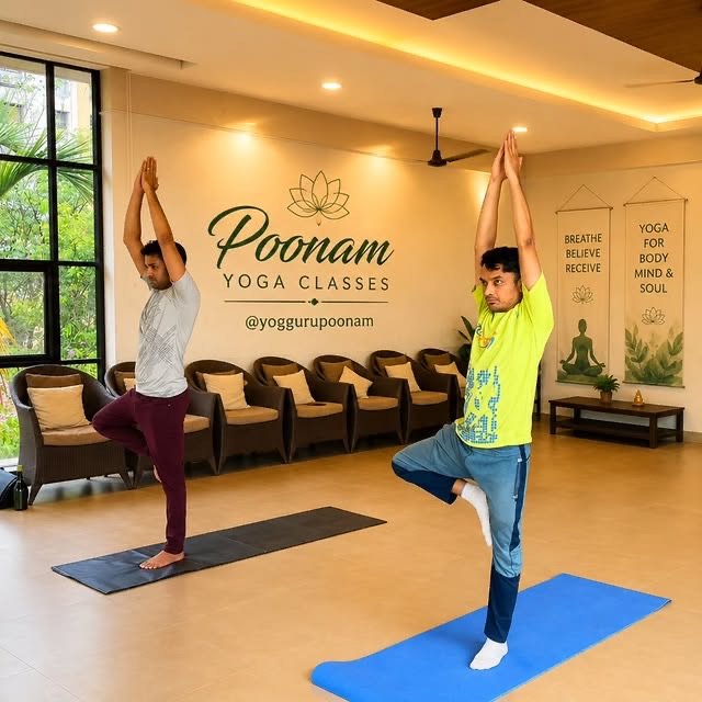 Two students balancing in tree pose during a studio yoga session